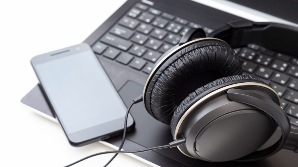 Telefon i słuchawki leżą na laptopie Laptop nie wykrywa słuchawek