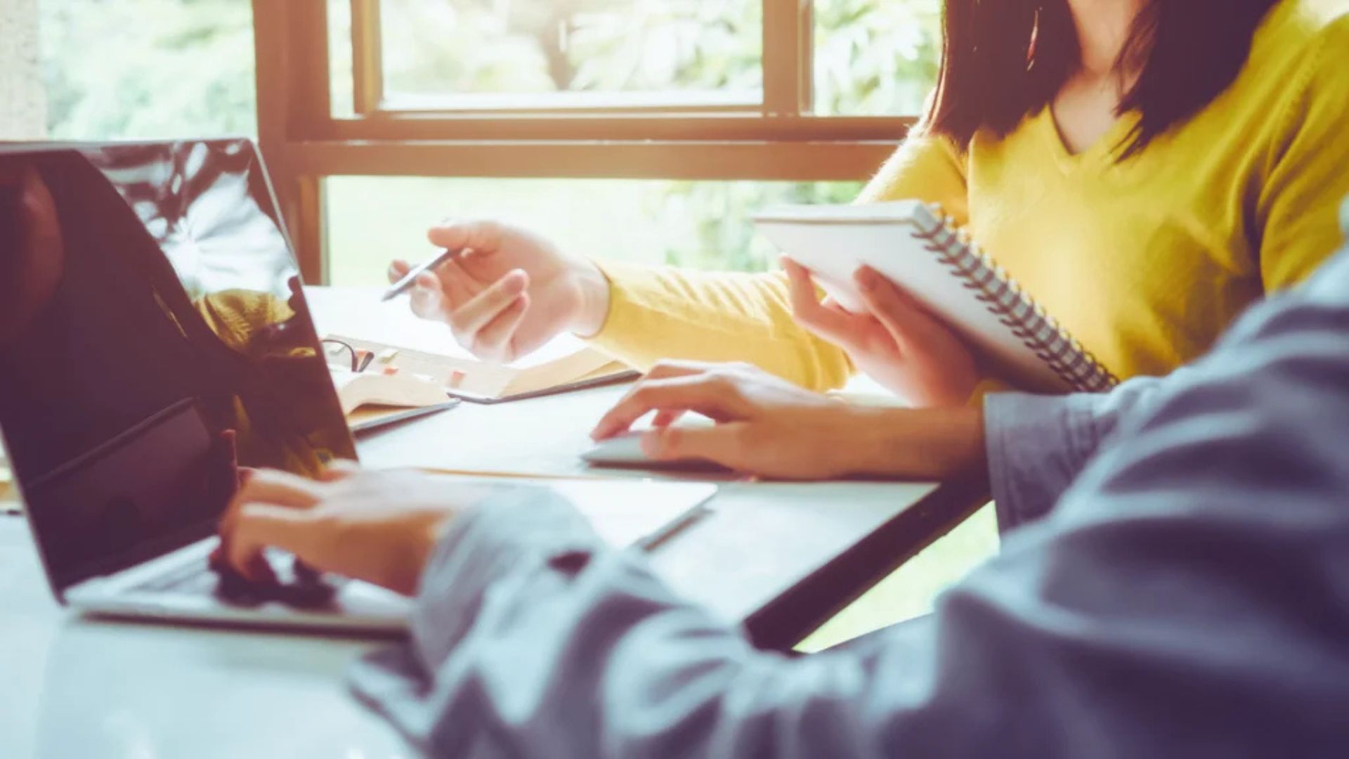 Laptopy dla studentów, dwie osoby pracują na laptopach.