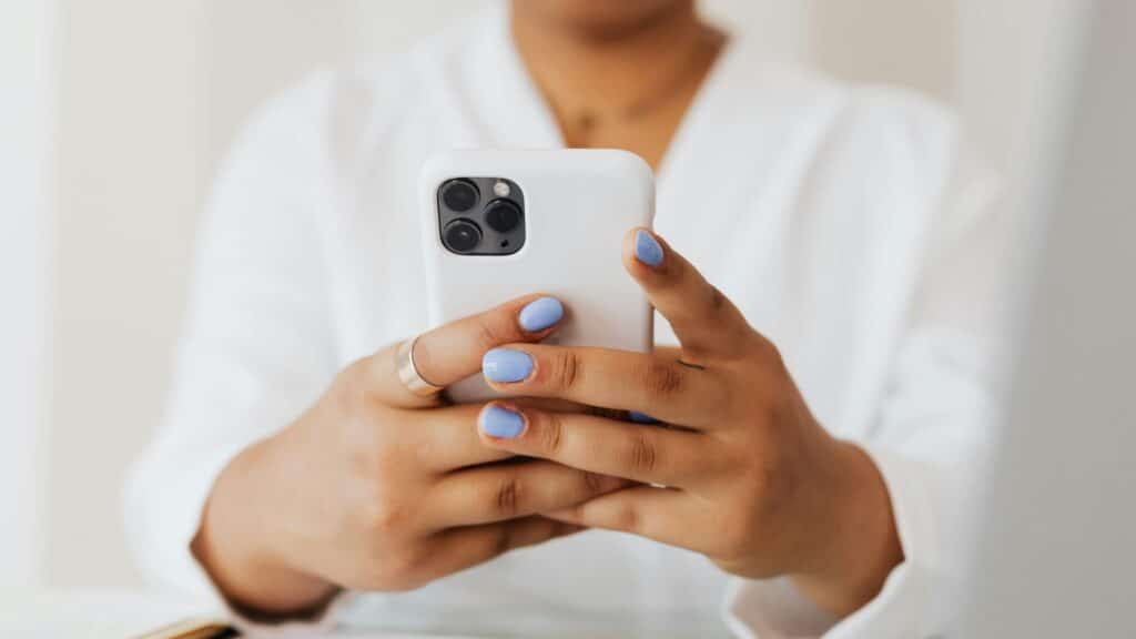 kobieta trzyma w ręku iphone kobieta się zastanawia jak przyspieszyć działanie iphone