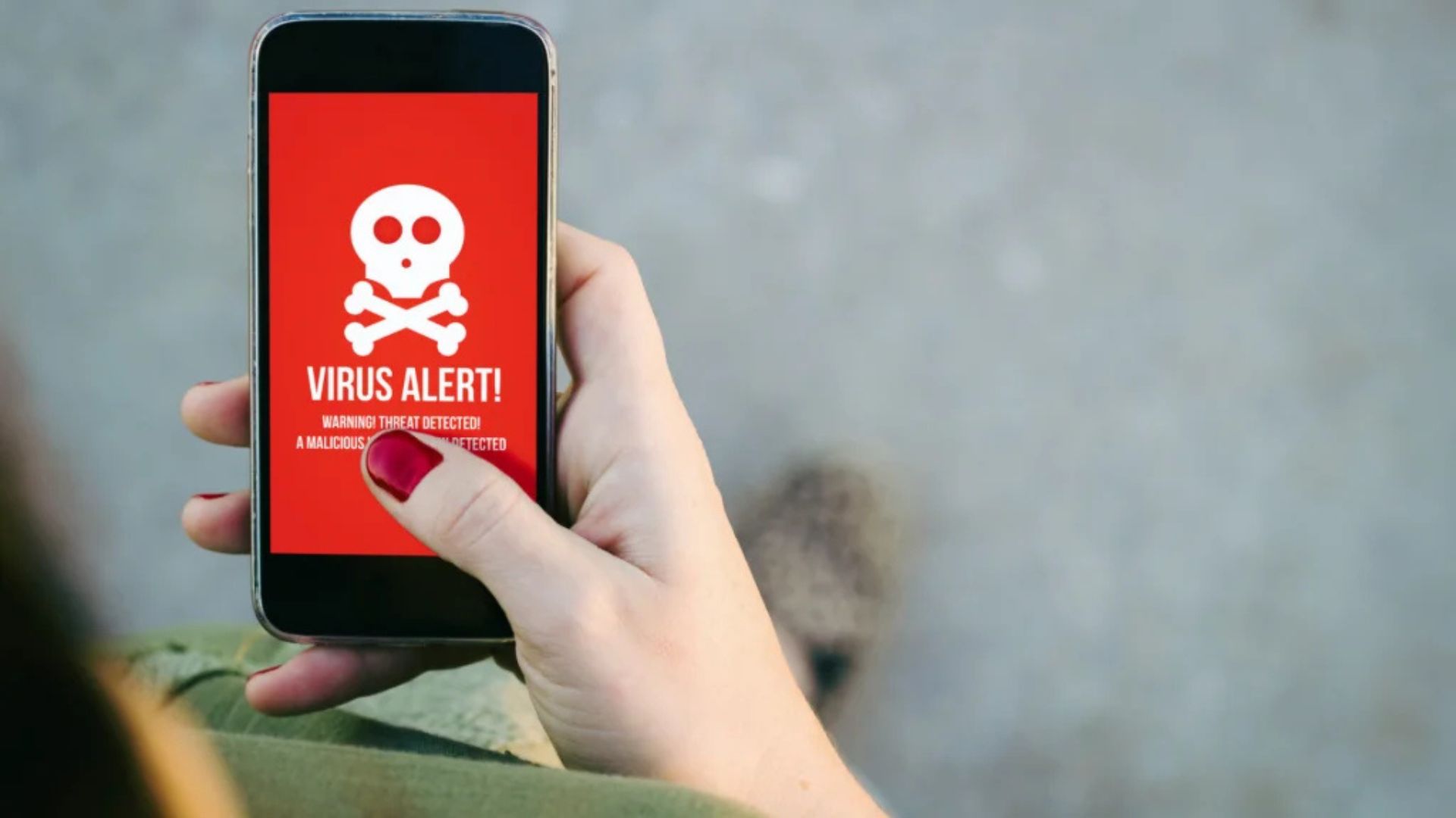 Oczyścić telefon z wirusów, telefon z widocznym wirusem na ekranie.