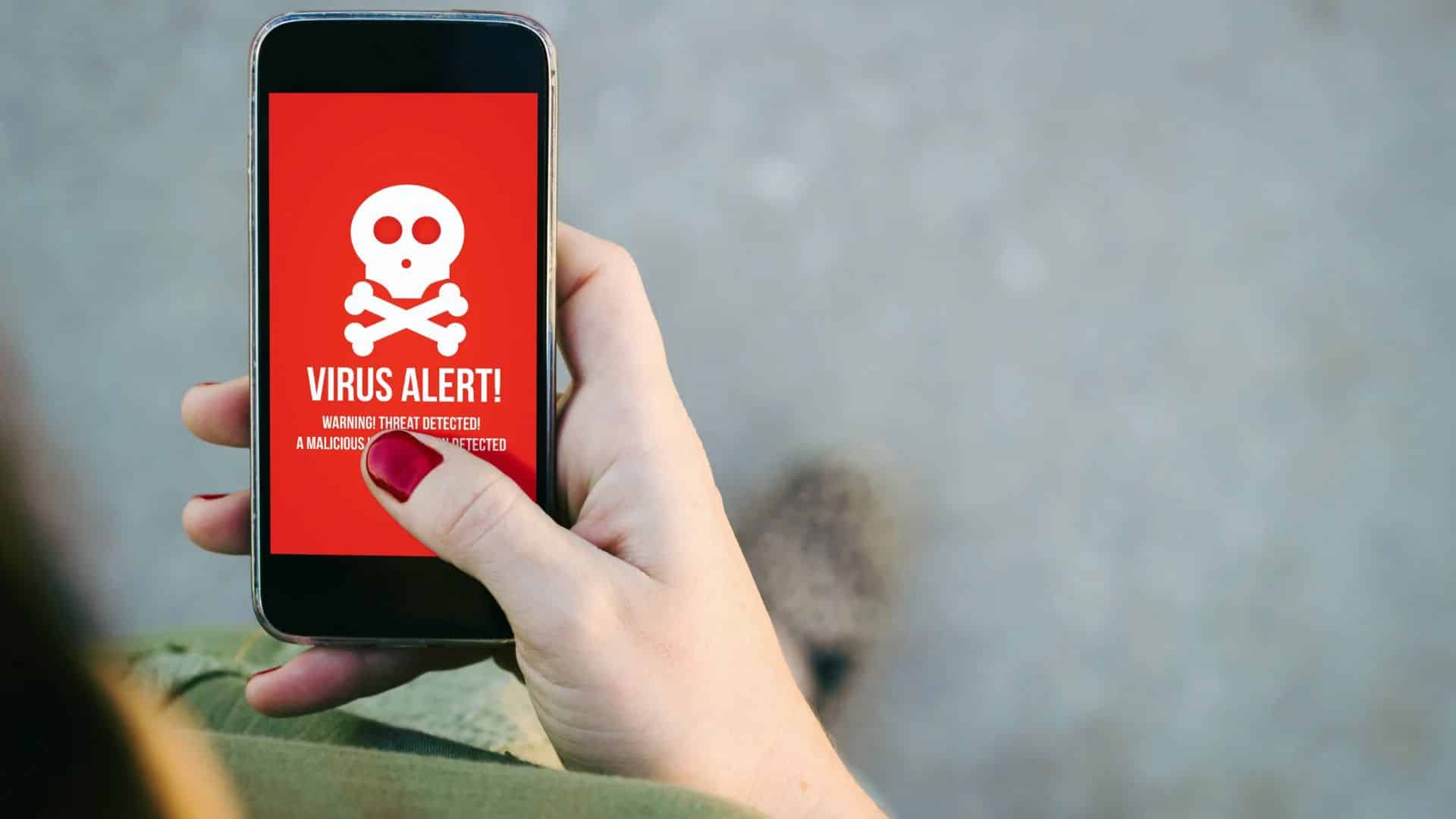 Oczyścić telefon z wirusów, telefon z widocznym wirusem na ekranie.