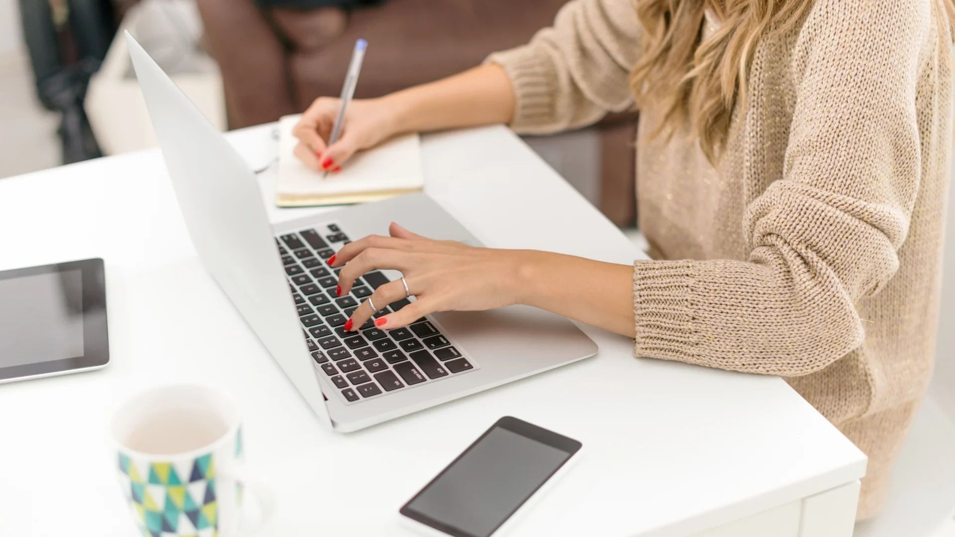 Kobieta siedzi przy biurku z laptopem, laptop do 3000,