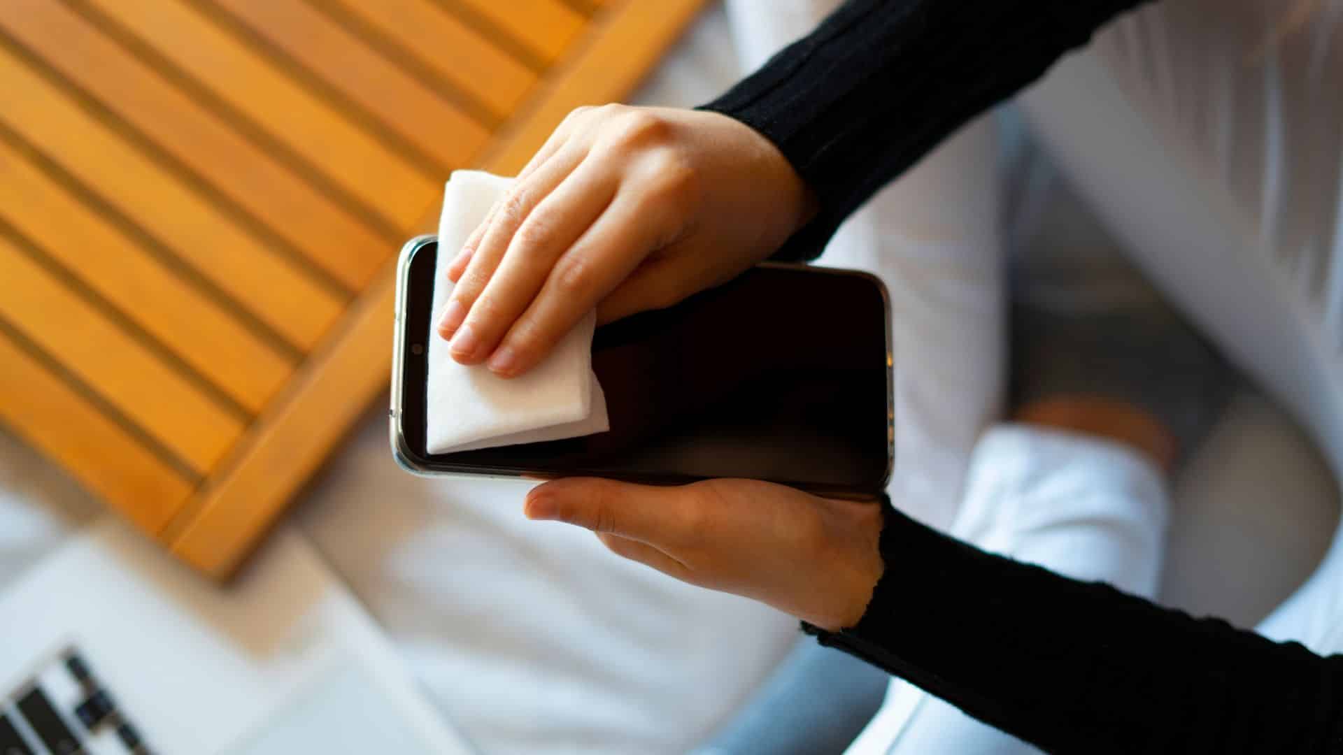 Jak dbać o iPhone. Pan czyści telefon.