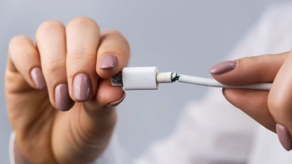 przerwany kabel w ładowarce trzymany w rękach