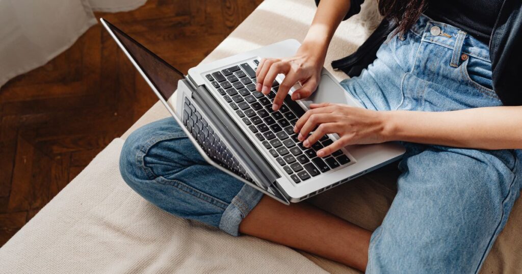 kobieta pracuje na laptopie kobieta pisze na laptopie siedząc na łóżku