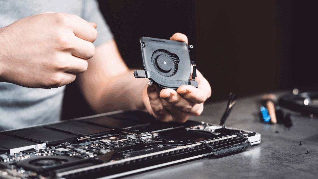serwisant naprawia wentylator  chłodzenia procesora w laptopie