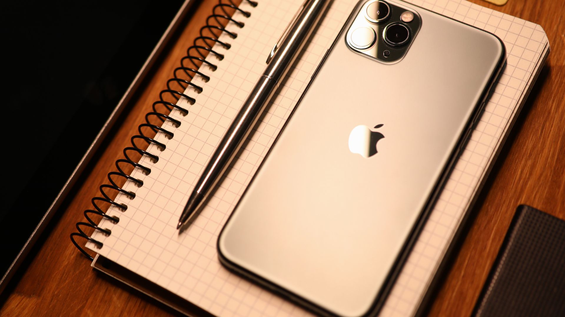 Jak przyspieszyć działanie iPhone, telefon leży na notatniku.