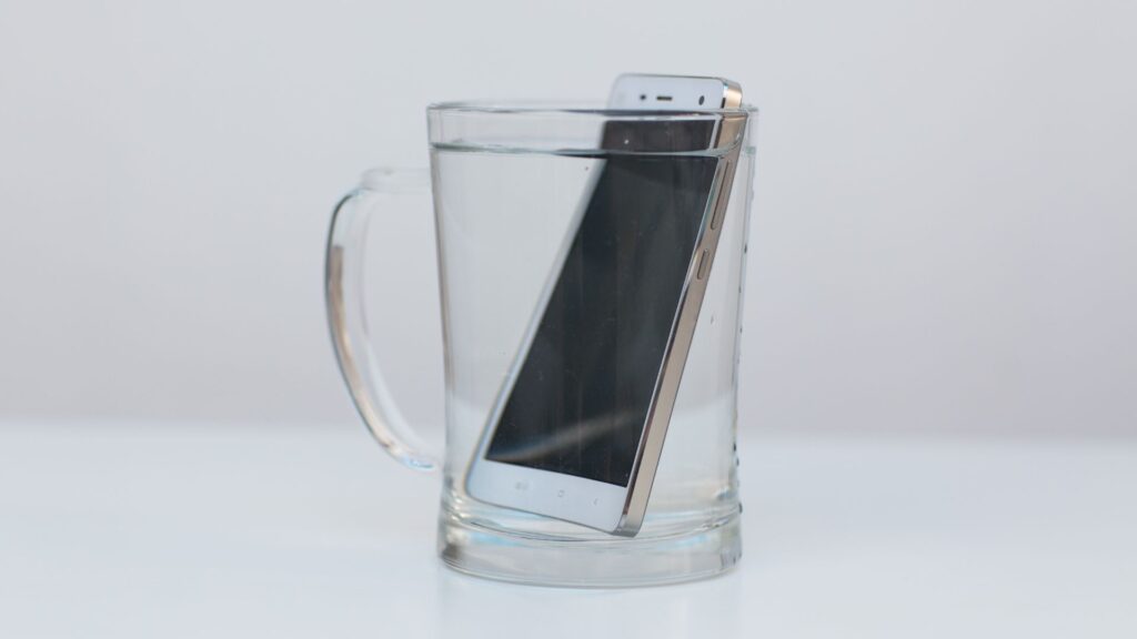 iphone w szklance z wodą iphone po zalaniu wodą