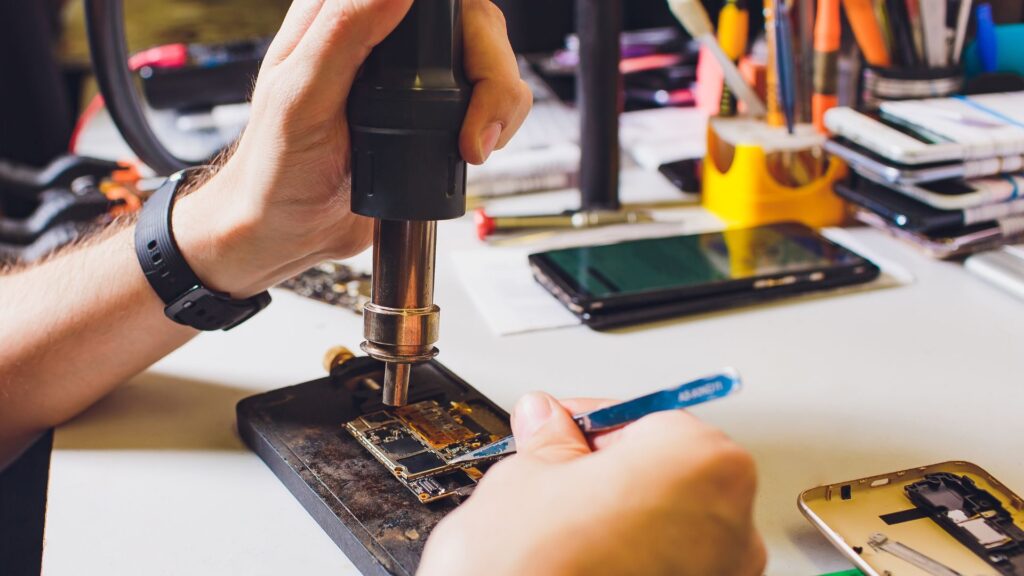 serwisant naprawia mokry telefon serwisant naprawia smartphone po zalaniu